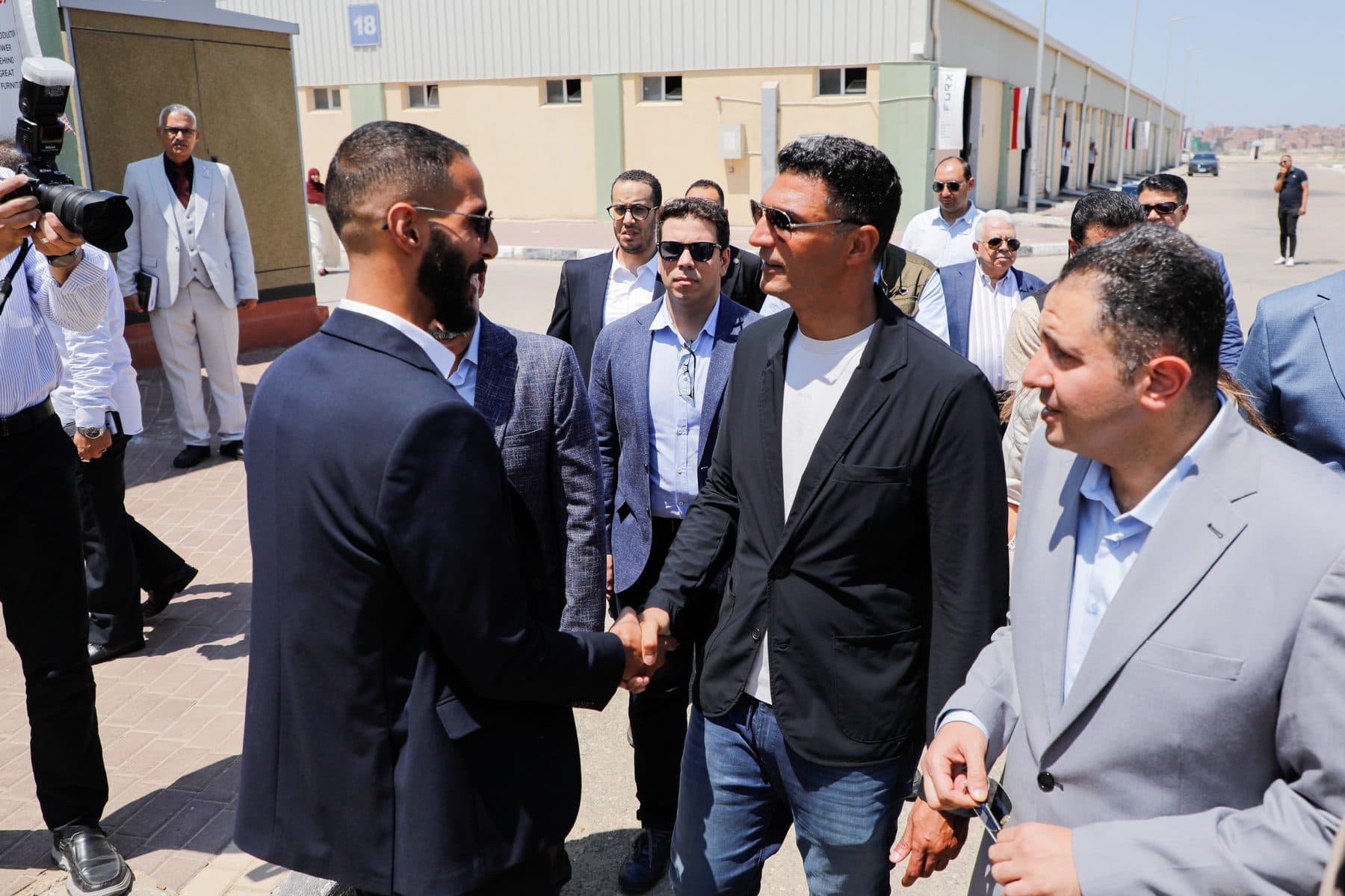 Eng. Waleed El-Banna shakes hands with Minister Khaled Hashem outside the FURX unit; Governor Hossam El-Din Fawzy stands alongside.